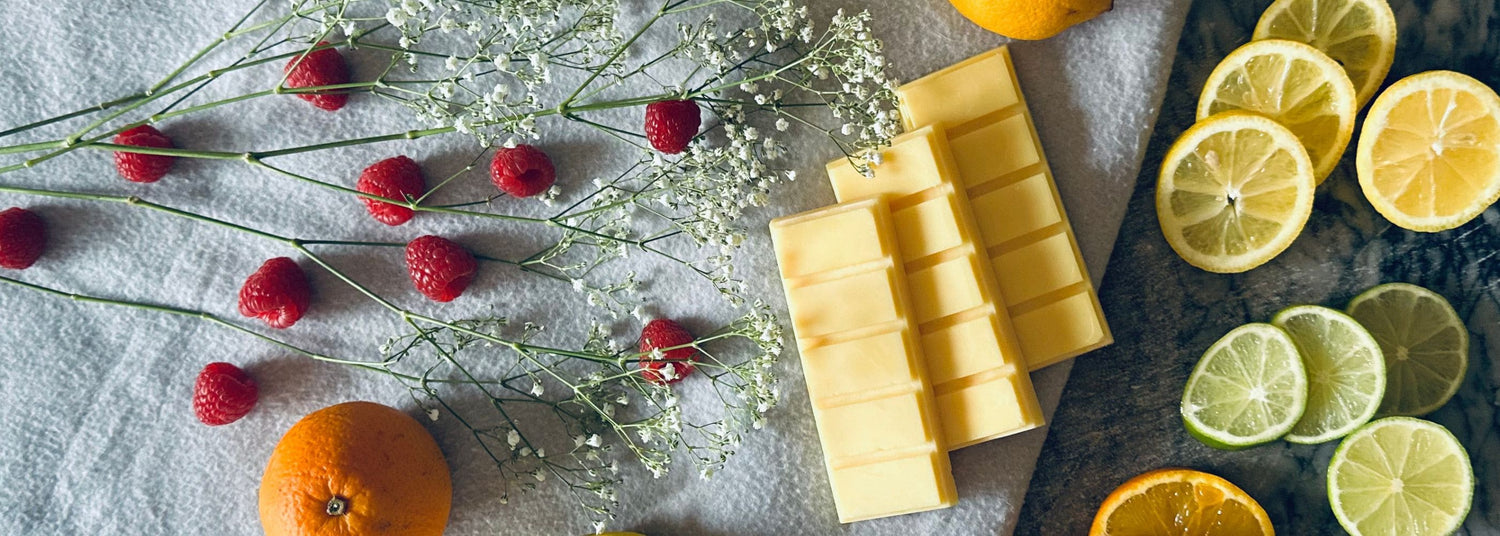 Clean and Fresh Wax Melts - citrus lemon yellow soy wax melts on a cotton blanket surrounded by lemons, oranges and limes