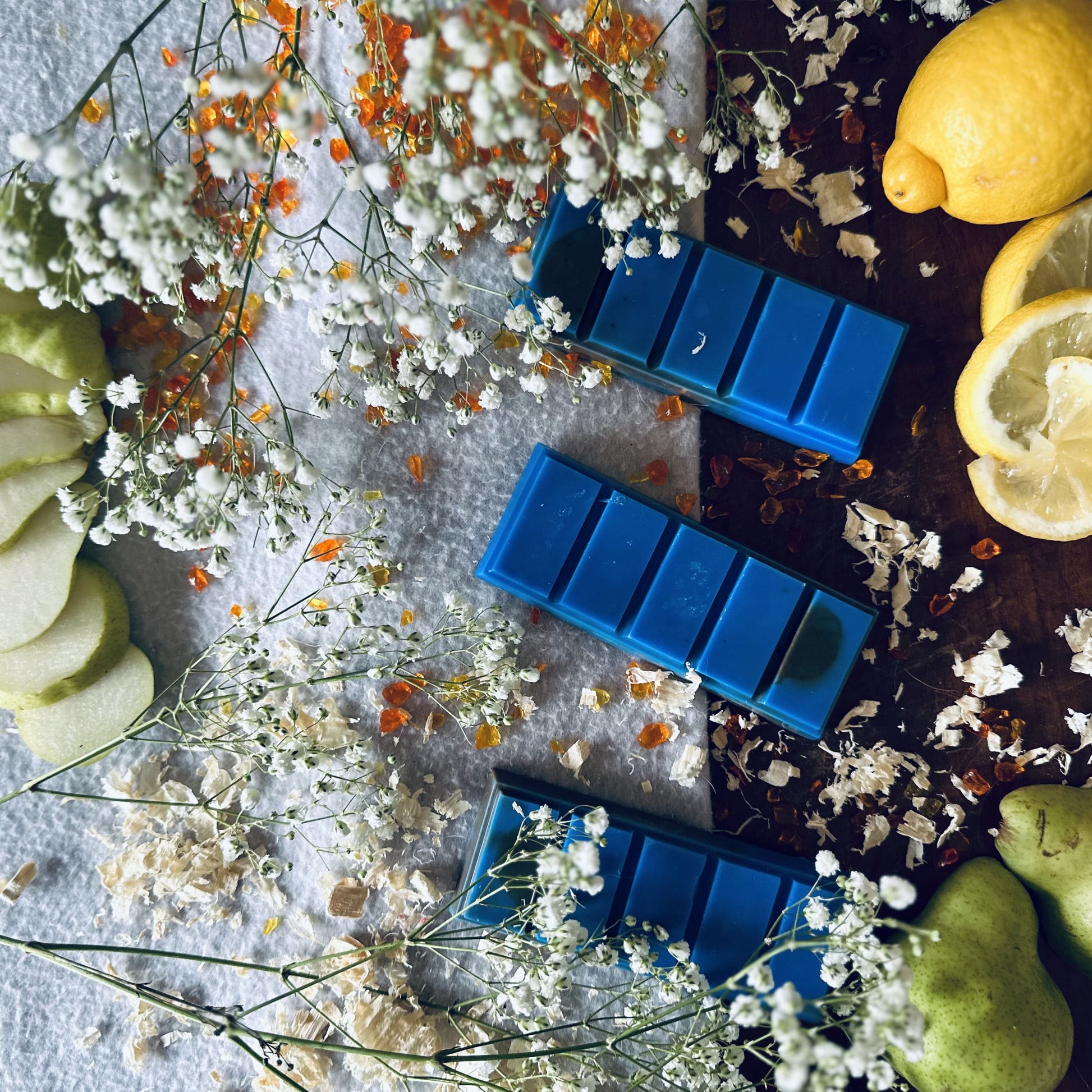 Blue soy wax melts surrounded by pears, lemons and flowers