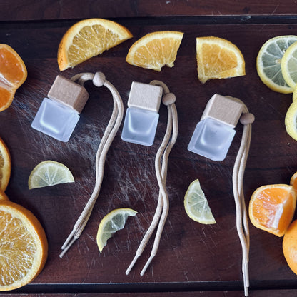 Blood orange scented car diffusers surrounded by oranges and lemons