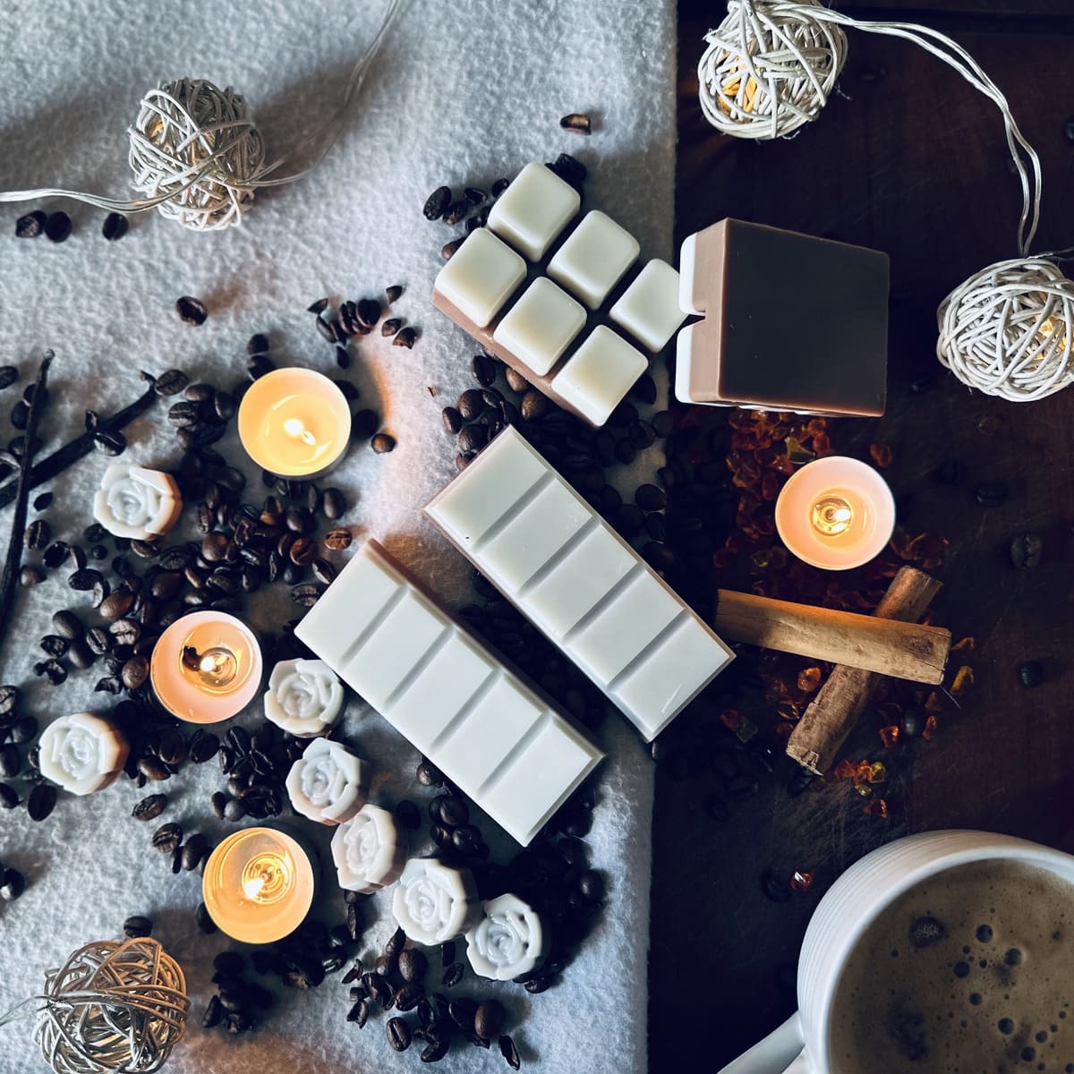 White and brown cappuccino scented soy wax melts surrounded by coffee beans, cinnamon sticks and vanilla pods