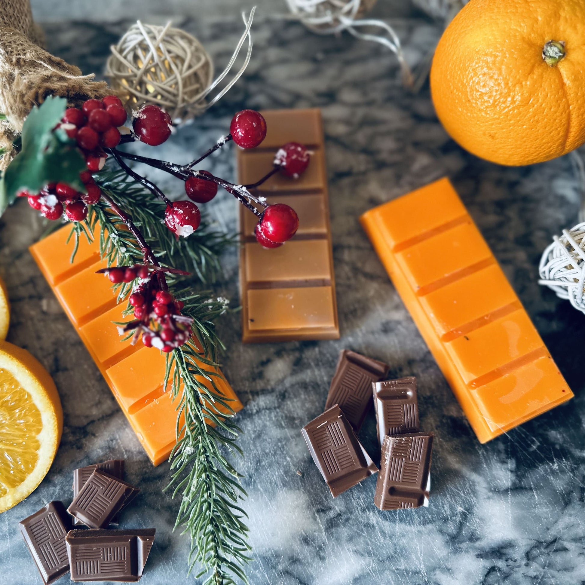 Chocolate orange scented orange and brown soy wax melts surrounded by milk chocolate and oranges