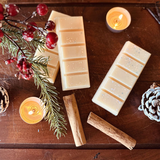 Cinnamon and vanilla scented soy wax melts surrounded by tea lights and cinnamon sticks