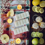 White coloured Frosty Lake scented wax melts on a red checkered cloth with lemons, candles, and christmas lights.