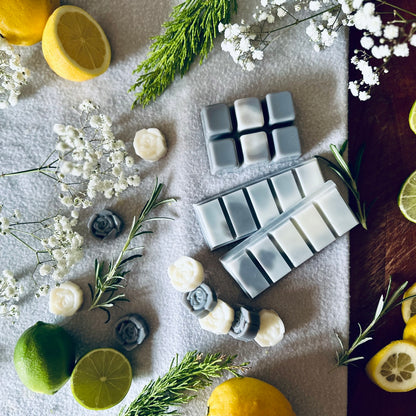 Grey and white soy wax melts in a spa relaxing setting surrounded by citrus fruits and white flowers