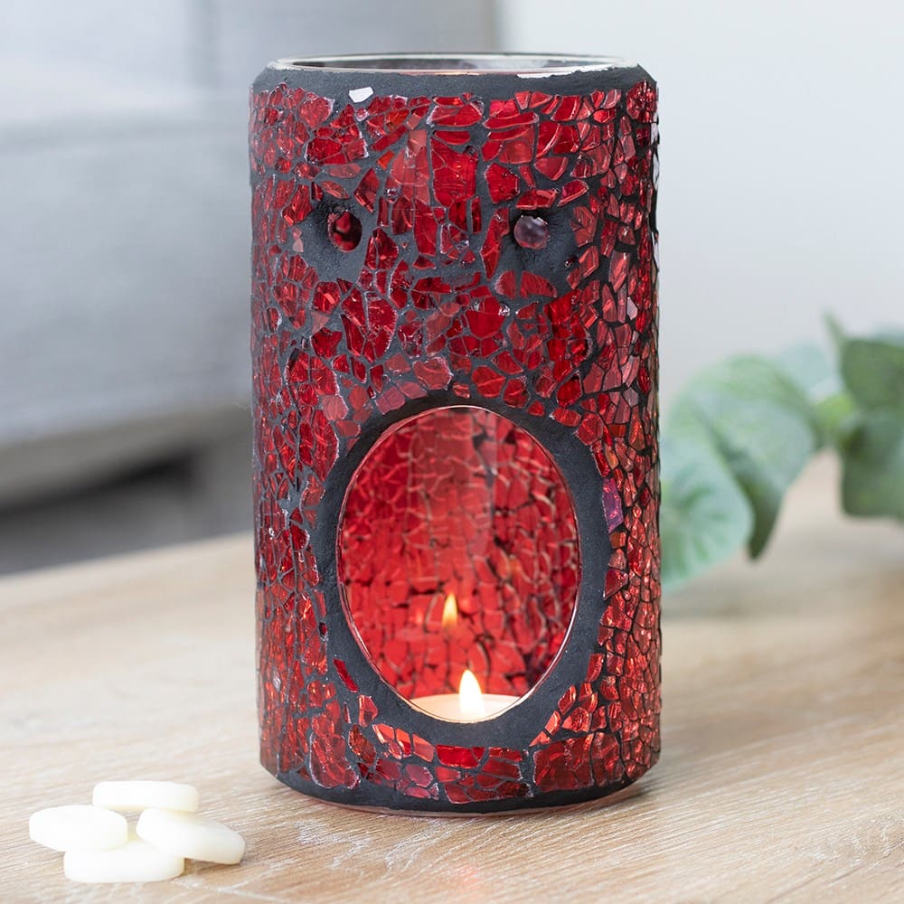 Red mosaic crackle glass effect wax melt burner with a lit candle inside on a wooden surface.
