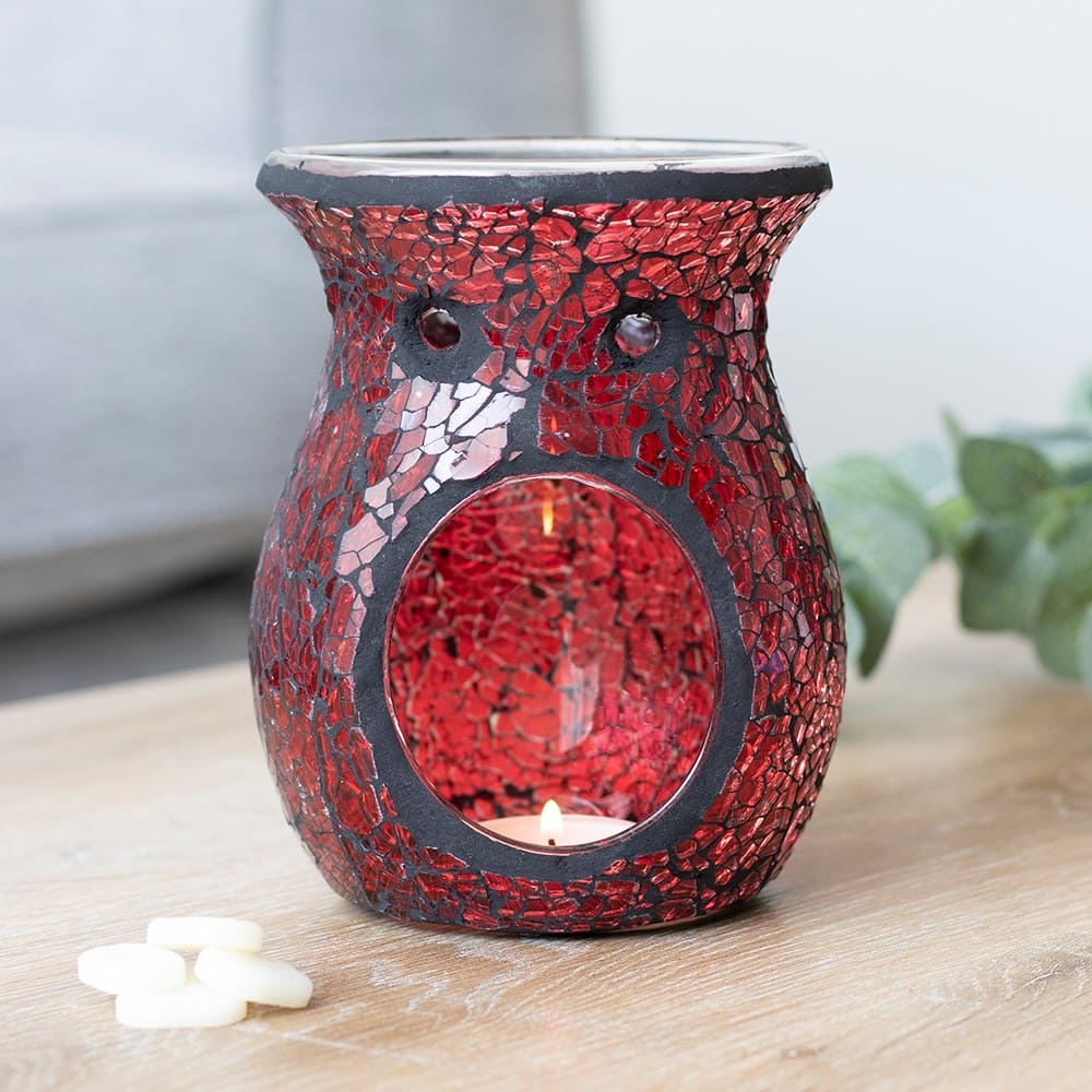 Red crackle effect case shaped wax melt burner on a wooden surface with a blurred background