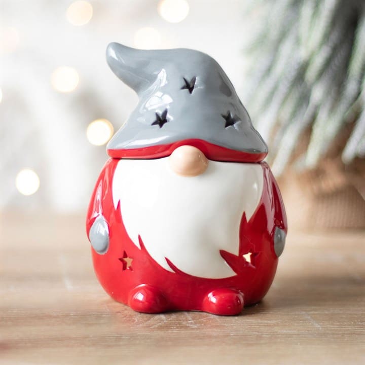 Santa styled Red gnome Gonk wax melt burner with a grey hat on a wooden surface with a Christmas background setting