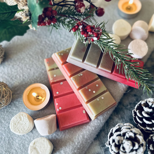 Red and green scented soy wax melts in a winter wonderland setting surrounded by fluffy marshmallow