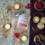 Snow Queen candle from Blissful Moments on a grey blanket surrounded by tea lights, raspberries and caramel