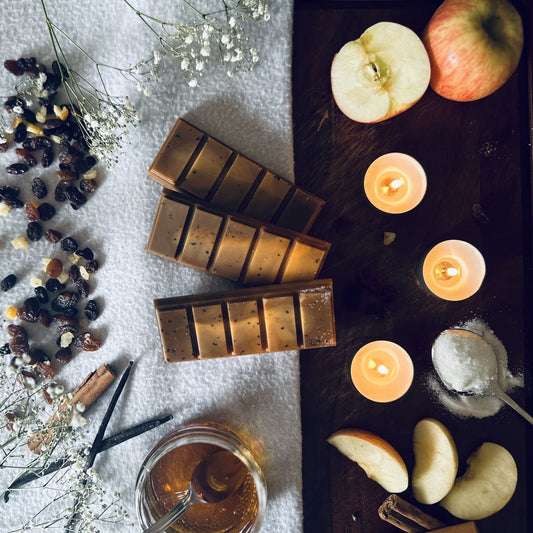 Brown soy wax melts surrounded by red apples, toffee, sugar and cinnamon in a Autumn setting