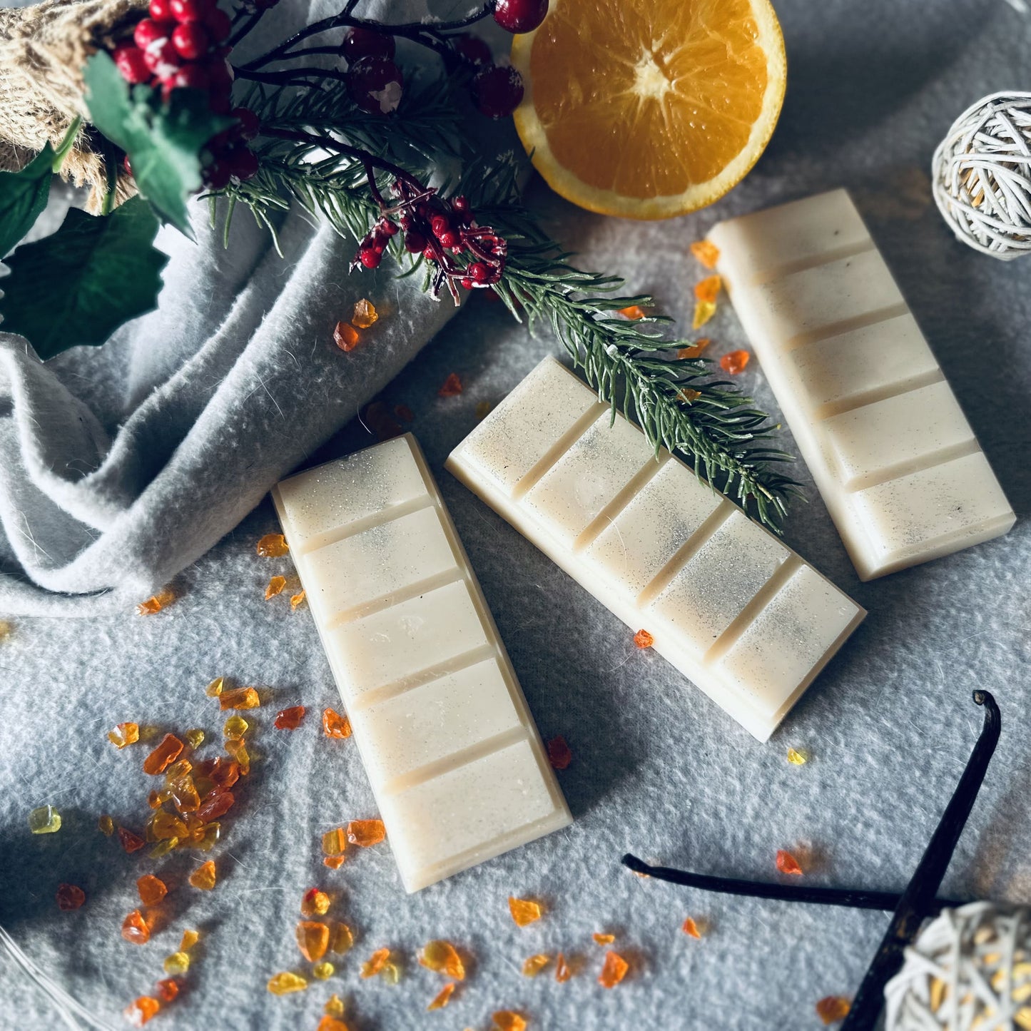 frankincense and myrrh soy wax melts sitting on a cosy wooly blanket in a Christmas winter wonderland setting