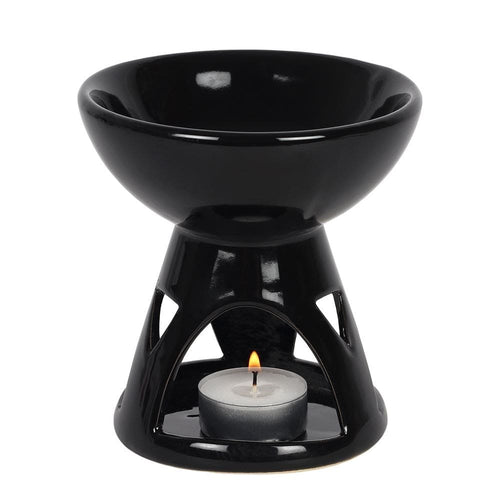 Black ceramic oil burner with a lit tealight candle on a white background