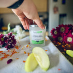 Forbidden Apple scented luxury frosted glass soy candle surrounded by fresh flowers, amber and green apples sitting on a cosy blanket