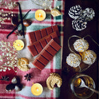 Red coloured Christmas Cookie scented snapbar wax melts on a checkered cloth surrounded by festive biscuits, chestnuts, caramel and pine cones.