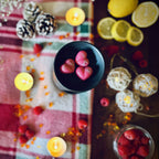 Christmas Wish scented heart shaped wax melts in a festive Decorative setting with berries, candles, and lemons on a checkered tablecloth.