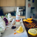 Luxury Mandarin & Clove scented rom spray surrounded by fresh flowers and citrus rooms sitting on a cosy blanket