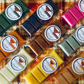 Assorted autumn wax melt snap bars in clear packaging with 'Blissful Moments' labels on a patterned fabric background.