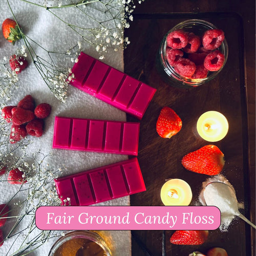 Pink fairground candy floss wax melt snapbars on a grey fabric background