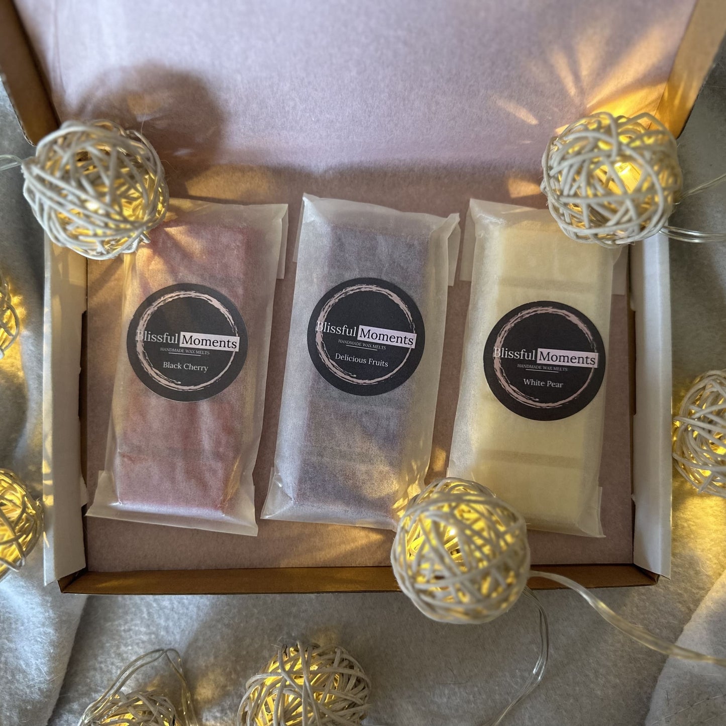 Red, purple and white fruity soy wax melts in a lovely presented gift box surrounded by fairy lights