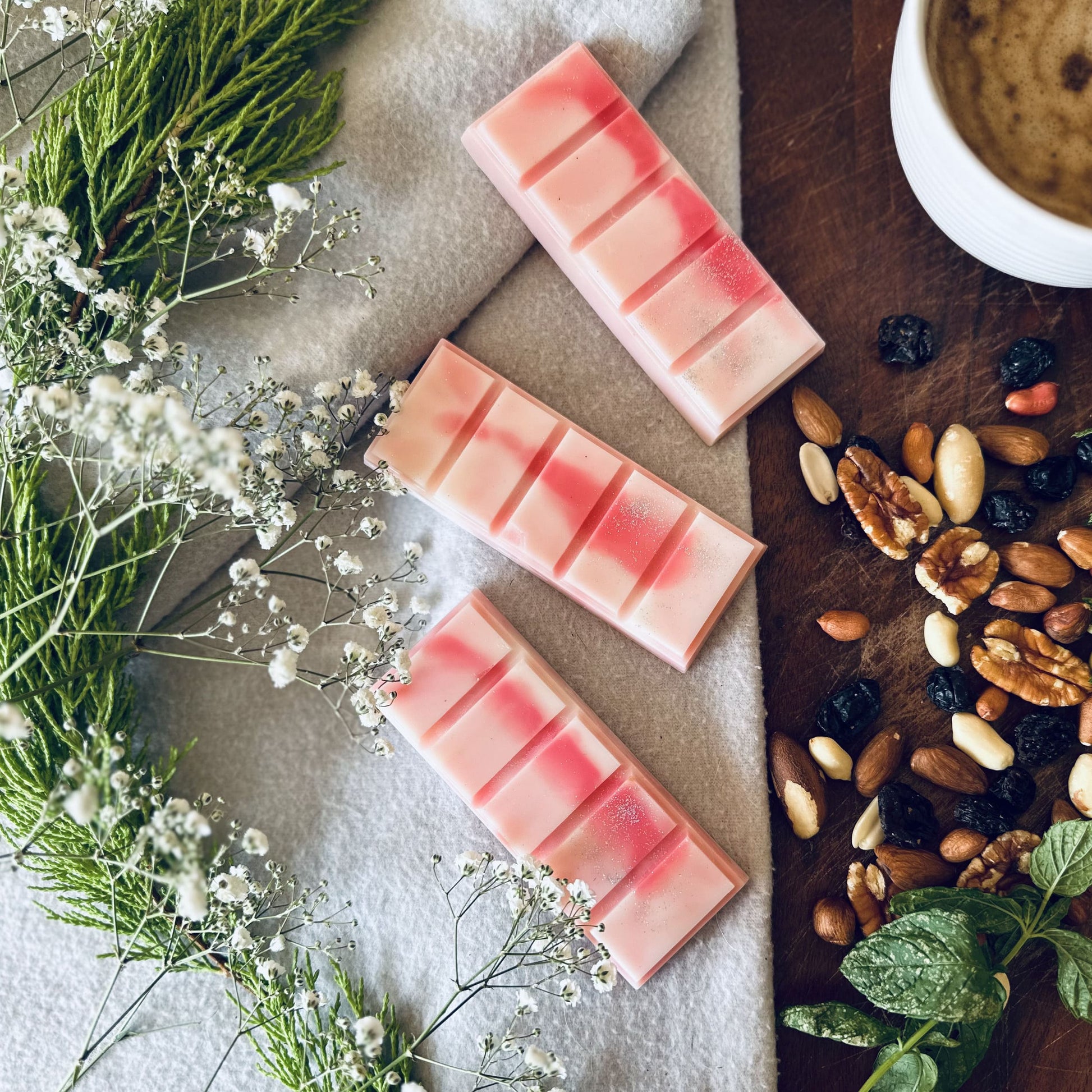 North Pole soy wax melts inspired by candy cane scent surrounded by mixed fruit and wild mint sitting on a luxurious brown board